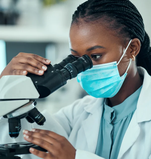 Kenyan female researcher using a microscope at CRK-NGO clinical research site