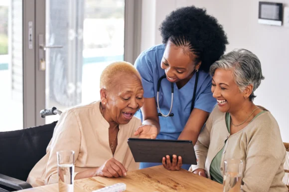 Nurse engaging elderly women with digital health education in Kenya, promoting trust and community healthcare empowerment.