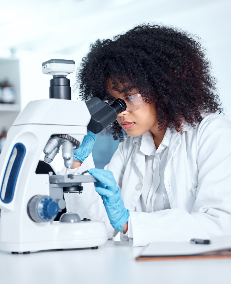 Kenyan female researcher analyzing samples under a microscope for CRK NGO publications and clinical research studies